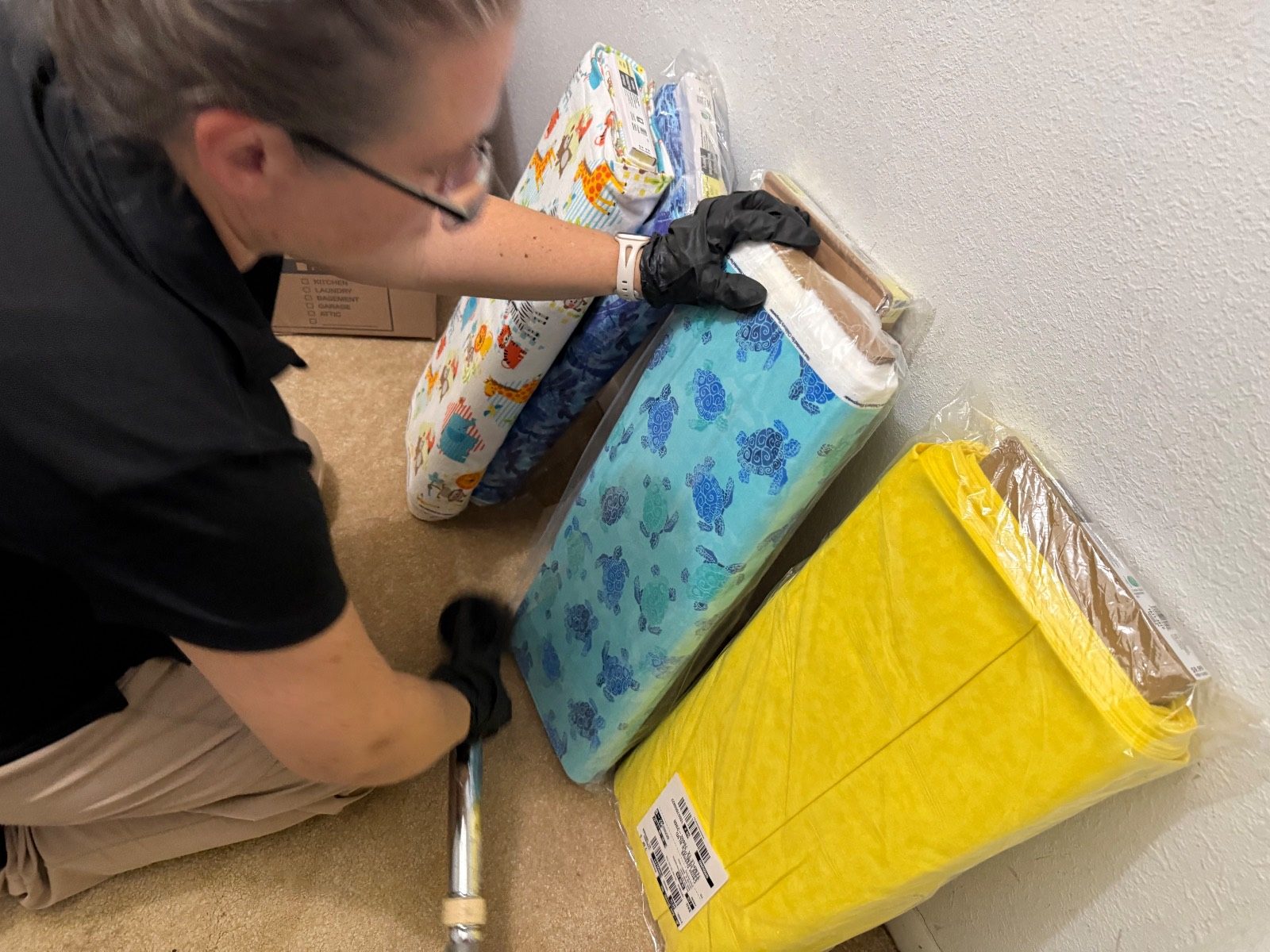 Technician cleaning and sorting belongings beside wrapped contents