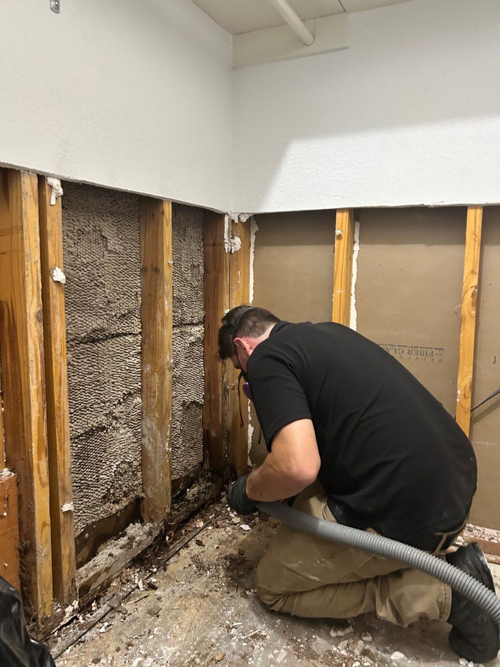 Technician inspecting and drying the inside of an open wall cavity