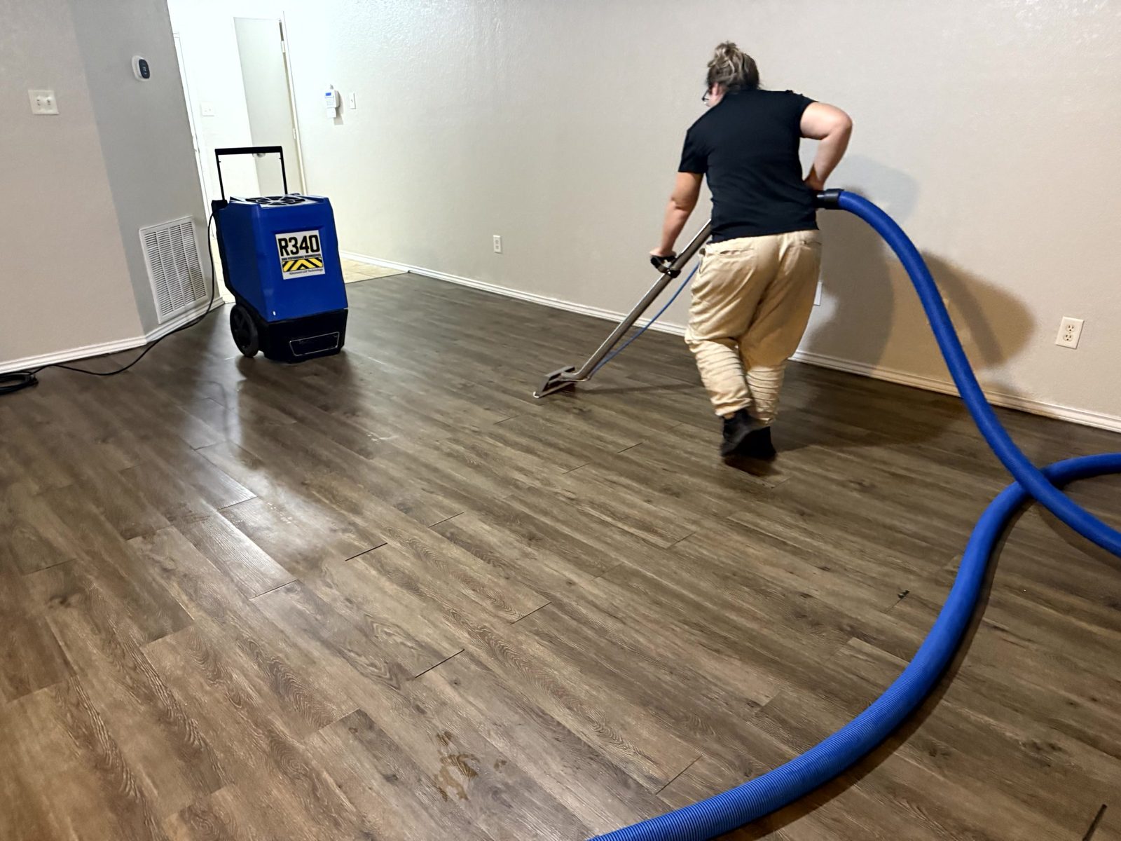 Technician extracting water from wood-look flooring