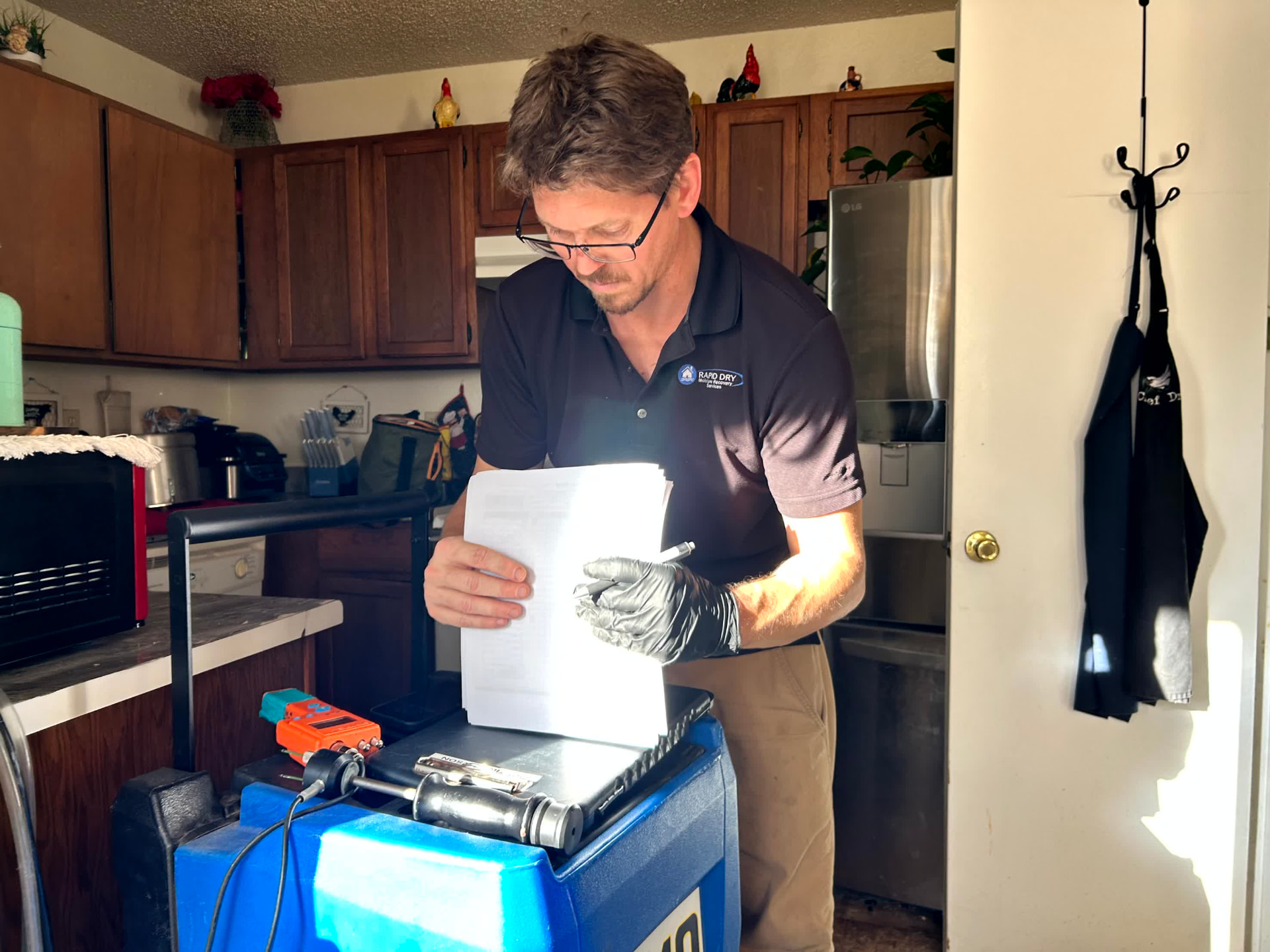 Rapid Dry technician reviewing job documentation and moisture readings for an insurance claim