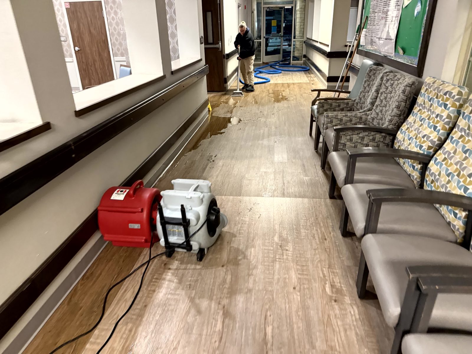 Row of air movers drying a corridor behind a containment barrier